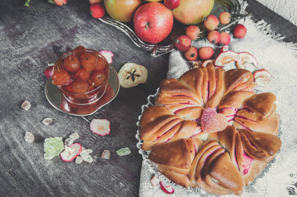 torta de maçã recém-assada com maçãs e geleia caseira feita de pequenas maçãs ao fundo. deliciosa torta caseira fresca e macia - apple cake spread macro - fotografias e filmes do acervo