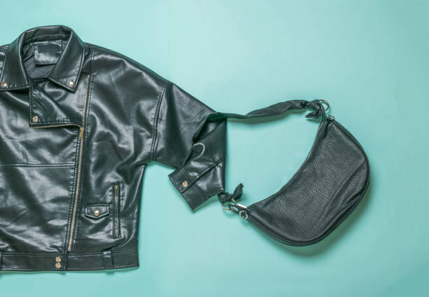 istock Women's black leather jacket with a bag on a blue background. 1342837013