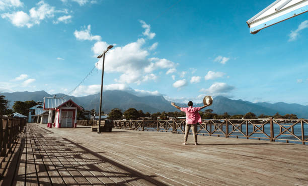 touristischer hafen der stadt la ceiba, atlantida, honduras. tourist mann mit hut auf einem pier. - honduras stock-fotos und bilder