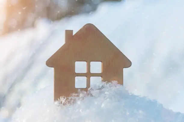 Photo of small wooden house close-up in winter, on a background of snow. Idea - winter discounts for home purchases, 2021 sales, New Year discounts. affordable housing, mortgage. Horizontal photo.