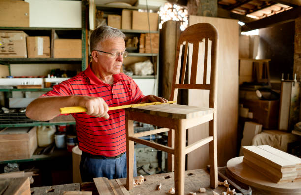 istock Senior man measuring a chair on a bench in his carpentry workshop 1342846952