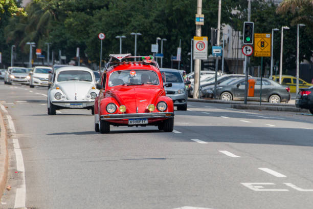 Beetle car on Copacabana Beach in Rio de Janeiro, Brazil - June 20, 2021: Beetle passing by Avenida Atlantica in Copacabana neighborhood
