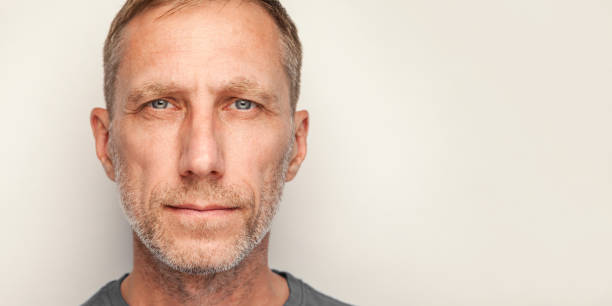 male close-up studio portrait isolated against white background - homens de idade mediana imagens e fotografias de stock