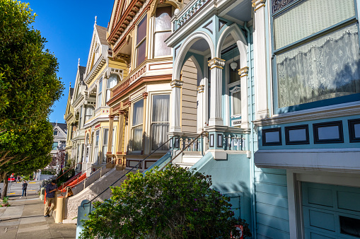 October 7, 2018 - San franscico, United States: tourists in front of The Painted Ladies of San Francisco, historic victorian style colourful houses under blue summer sky. Alamo Square, San Francisco, California, USA.
