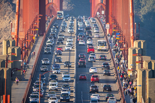 october 7, 2018 - San Francisco, United States: pedestrians walking and cars driving at sunset over golden gate bridge, San Franscisco, California, USA