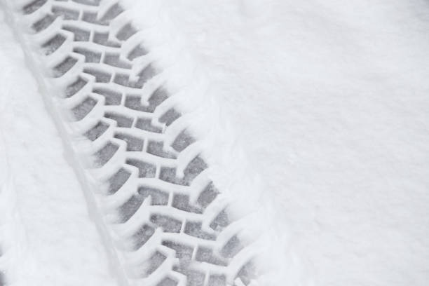 istock Car tire tracks in fresh snow on the road. Snowfall 1342866230