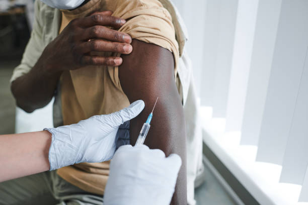 istock Close-up of unrecognizable nurse in gloves holding filled syringe while determining injection site on patients arm 1342884076