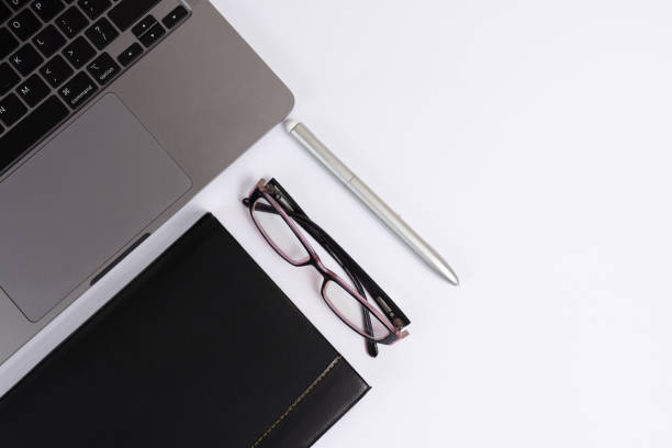 istock White office desk with laptop notepad, eyeglasses. Tabletop. Top view, copy space. Workplace. 1342885244