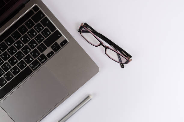 istock White office desk with laptop, eyeglasses. Tabletop. Flatly, copy space. Workplace. 1342886316