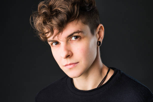 Non binary business headshot from a mid hispanic androgynous headshot portrait from a non-binary Hispanic non binary looking at camera with confident identity. short hair studio portrait for gender education non binary gender stock pictures, royalty-free photos & images