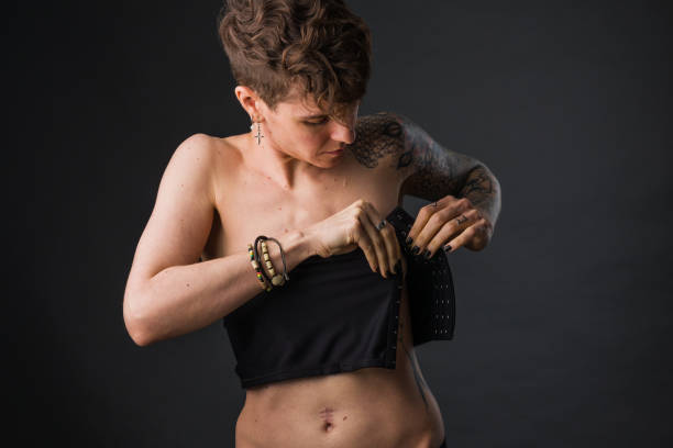 non-binary gender model adjusting breast binder - peito imagens e fotografias de stock