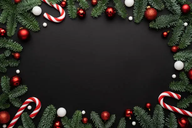 Photo of Black background with Christmas decorations of fir branches and Christmas balls