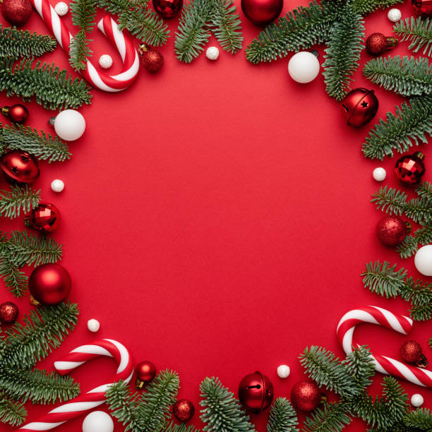istock Frame made of Christmas decorations fir branches on a red background 1342898887