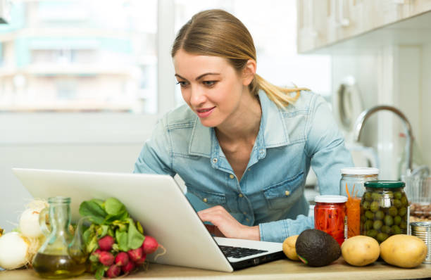 istock Young woman cooking recipe from the Internet 1342901568