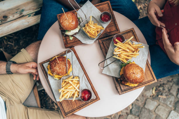 High angle shot of a group of friends eating burgers and fries out