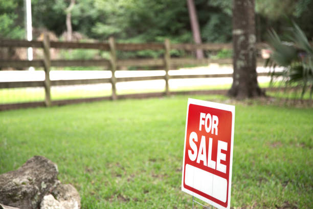 Real estate sign on Vacant Lot or front yard of Home for Sale. stock photo