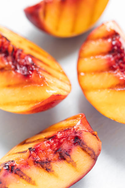 istock Juicy grilled nectarine quarters on light gray cutting board. 1342929832