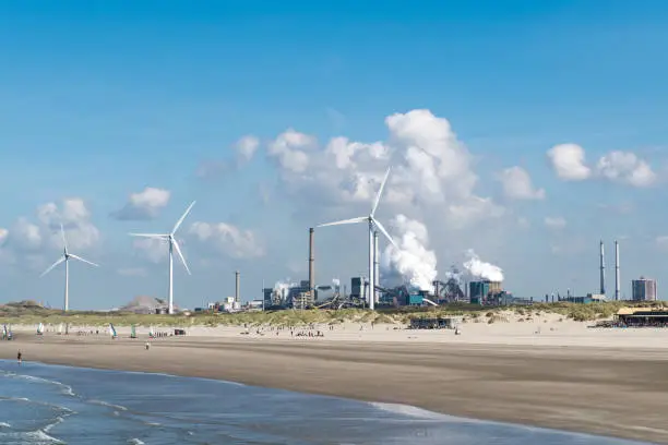 The beach with beach clubs and wind turbines next to the heavily polluting Tata Steel steel mill in IJmuiden.
