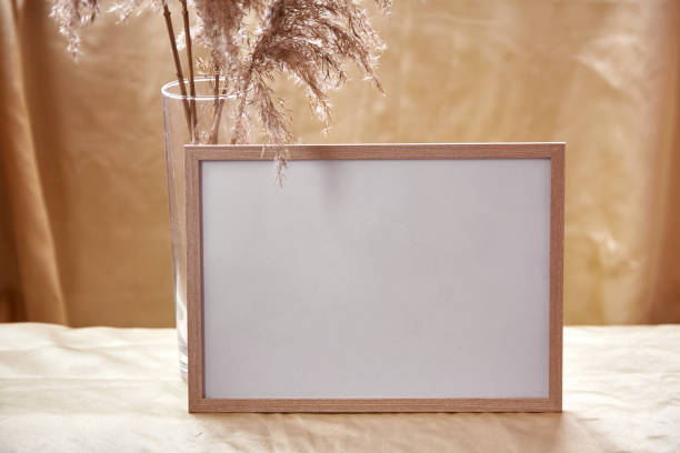 istock Minimalistic mock - up frame with dry flowers decorations. Cozy home atmosphere mockup. Natural beige background 1342937448