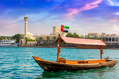 Abra - old traditional wooden boat and Al Farooq Mosque on the bay Creek in Dubai, United Arab Emirates