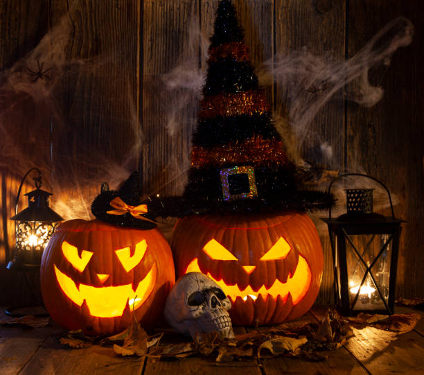 istock Halloween Jack-o-Lantern Pumpkins on rustic wooden background 1342949913