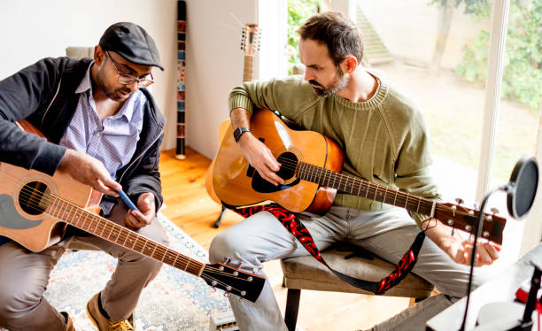 istock Two musicians looking at something on a phone during rehearsal 1342953497