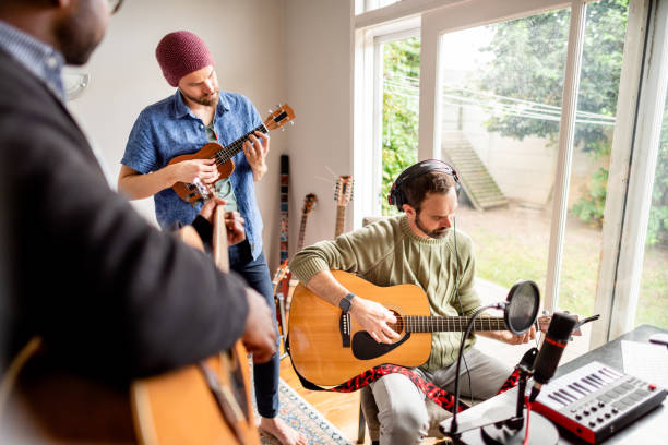 musicians recording a rehearsal together in a home music studio - band 40s imagens e fotografias de stock