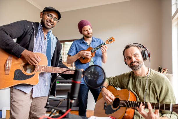 band sorridente che suona una sessione di musica acustica in uno studio domestico - sequenza di strumento musicale foto e immagini stock