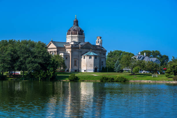 Gothic Revival church with beautiful windows, dome, and spire against a blue sky, horizontal aspect