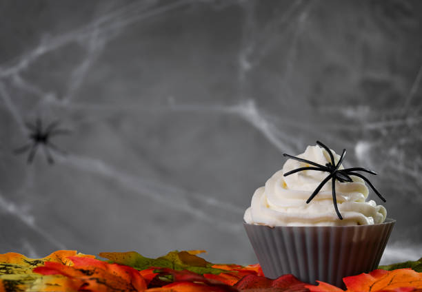 Halloween muffin or cupcake with white cream and spider decoration. Tasty and scary food on Halloween party Halloween muffin or cupcake with white cream and spider decoration. Tasty and scary food on Halloween party. halloween cupcake stock pictures, royalty-free photos & images