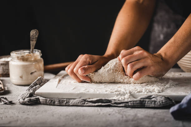 istock Woman hands kneading bread dough on kitchen counter 1342962404