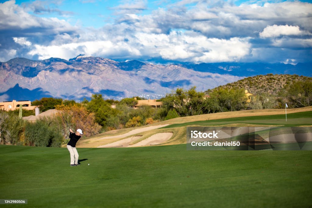 Retired Woman playing Golf in Tucson Arizona She is playing Golf in Tucson Arizona surrounded by cactus Adult Stock Photo