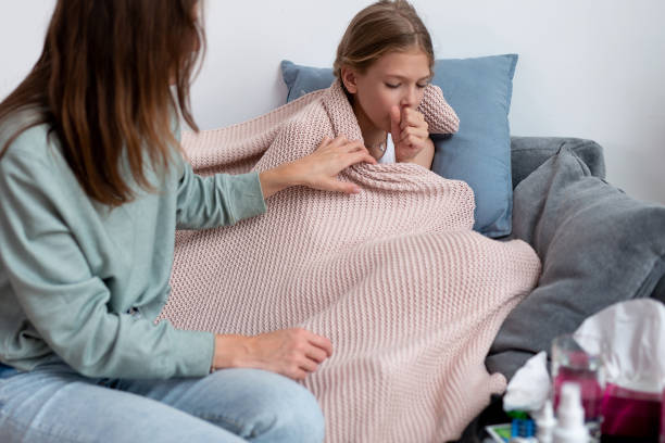 niña está enferma y tosiendo su madre se sienta a su lado - coughing fotografías e imágenes de stock