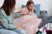 Girl Is Sick and Coughing Her Mom Sits Next To Her