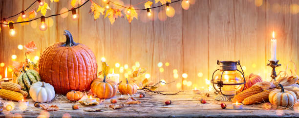 木のテーブルの上のカボチャ - 野菜とボケライトと感謝祭の背景 - illuminated leaves ストックフォトと画像
