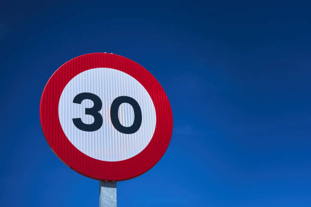 дорожный знак ограничения скорости 30 км/ч над голубым небом - prohibitory sign стоковые фото и изображения