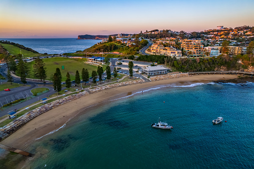 Clear skies aerial sunrise seascape with boats overlooking the coastal suburb of Terrigal on the Central Coast, NSW, Australia. Taken September 25 2021.