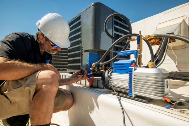 HVAC technician repairing an air conditioner stock photo