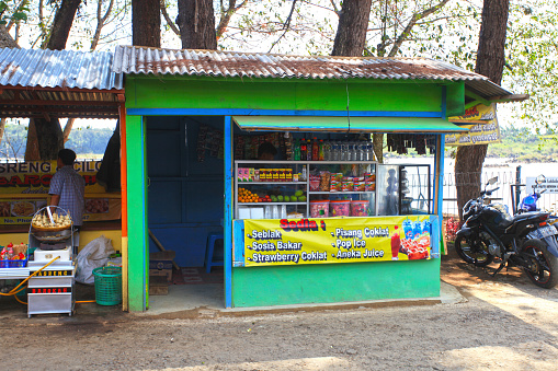 A small warung selling snacks and drinks in the village at Patenggang lake in Ciwidey, West Java, Indonesia. The lake can be seen in the background.