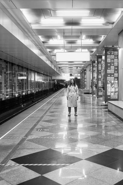 ragazza in un trench beige nella metropolitana in attesa del treno sulla piattaforma - 16707 foto e immagini stock