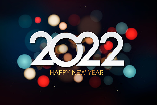 Happy new year 2022. Hanging white paper number with confetti on a colorful blurry background.