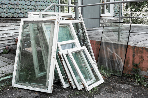 white wooden window frames with glass lie on the street