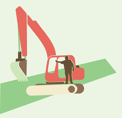 A man standing on a backhoe