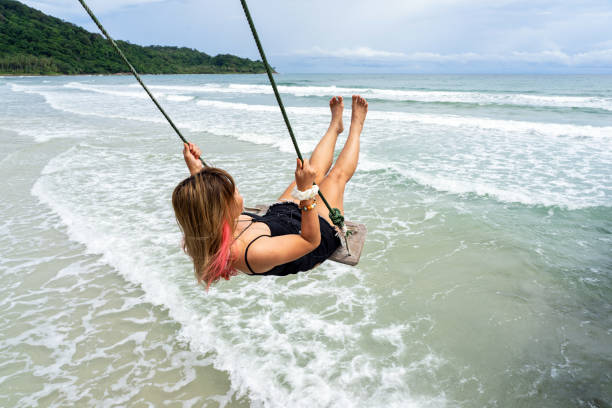 istock Asian female playing on beach swing with sea waves 1343052649