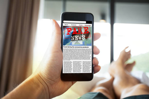istock Man reading fake news or articles about covid-19 in a smartphone screen application. 1343053021