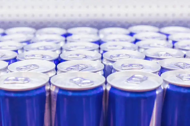 Photo of Cans with Energy drink in supermarket. Selective focus.