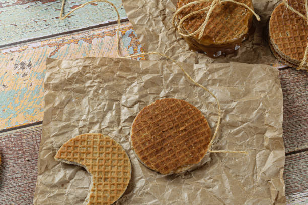 istock Stroopwafel with a bite on brown paper next to another cookie and sisal string. 1343062768