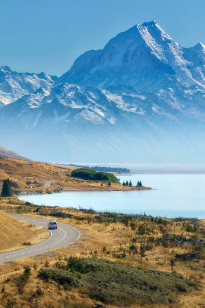 Summer Panorama of the road towards the famous Mount Cook along the turquoise Lake Pukaki. South Island, Canterbury, Mackenzie Basin, Mount Cook, Lake Pukaki, New Zealand Summer Panorama of the road towards the famous Mount Cook along the turquoise Lake Pukaki. South Island, Canterbury, Mackenzie Basin, Mount Cook, Lake Pukaki, New Zealand fox glacier photos stock pictures, royalty-free photos & images