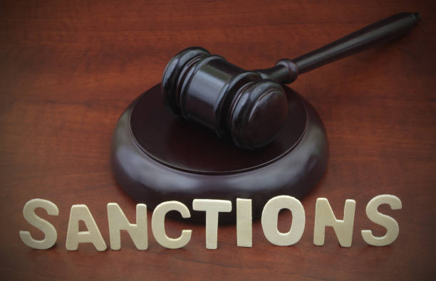 istock Judge gavel and word sanctions on wooden table. 1343080274