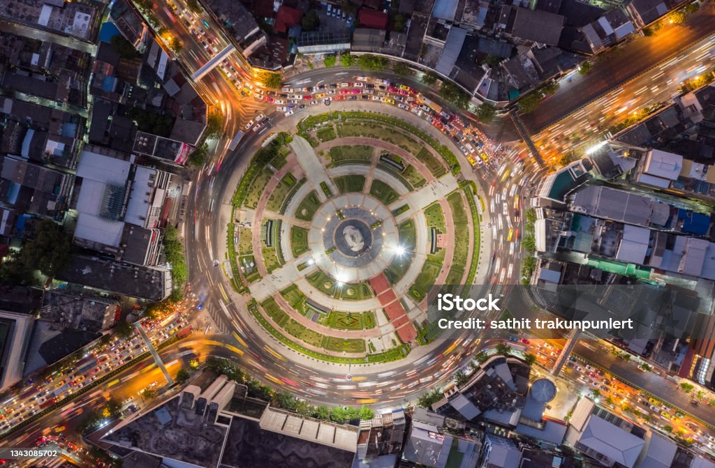 Road roundabout with car lots Wongwian Yai in Bangkok,Thailand. street large beautiful downtown at night light. Aerial view , Top view ,cityscape ,Rush hour traffic jam Abstract Stock Photo